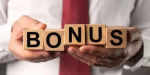 Una persona con camisa blanca y corbata roja sosteniendo una serie de cubos con la palabra bonus